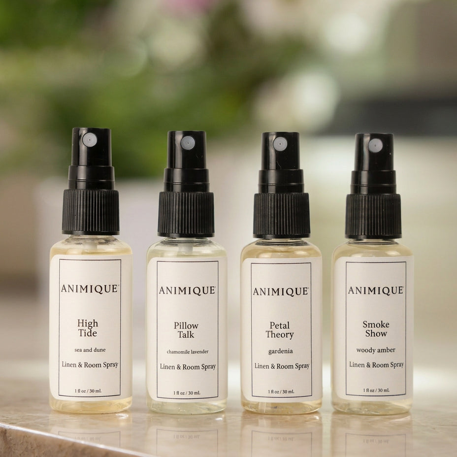 Four sample size bottles of linen and room spray by Animique — pet-safe home fragrance on a table.